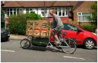 Man cycling uphill in a cargo bike
